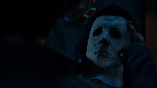 Screenshot from "Halloween: The Game" showing a character holding a white mask, creating a tense and eerie atmosphere.