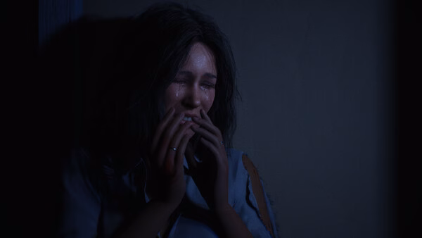 Screenshot from Halloween: The Game showing a distressed woman crouched in a dark corner, lit dimly with an eerie atmosphere.