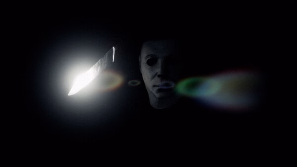 Screenshot from Halloween: The Game showing a masked figure holding a knife in a dark setting with eerie lighting.