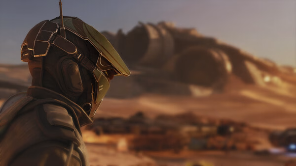 Screenshot from STAR WARS: Galactic Racer™ showing a racer in a green helmet overlooking a desert with wrecked ships in the background.