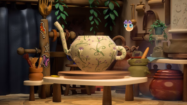 Screenshot from Kiln showing a detailed teapot with floral patterns on a pottery wheel in a cozy, decorated workshop.