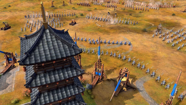 A screenshot from Age of Empires IV: Dynasties of the East showing a pagoda, trebuchets, and armies preparing for battle.