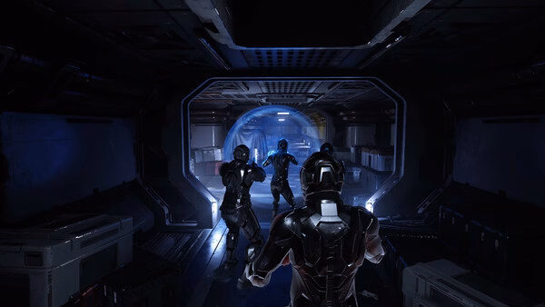 Screenshot from Species: Unknown showing armored characters exploring a dimly lit sci-fi corridor with glowing blue lights.